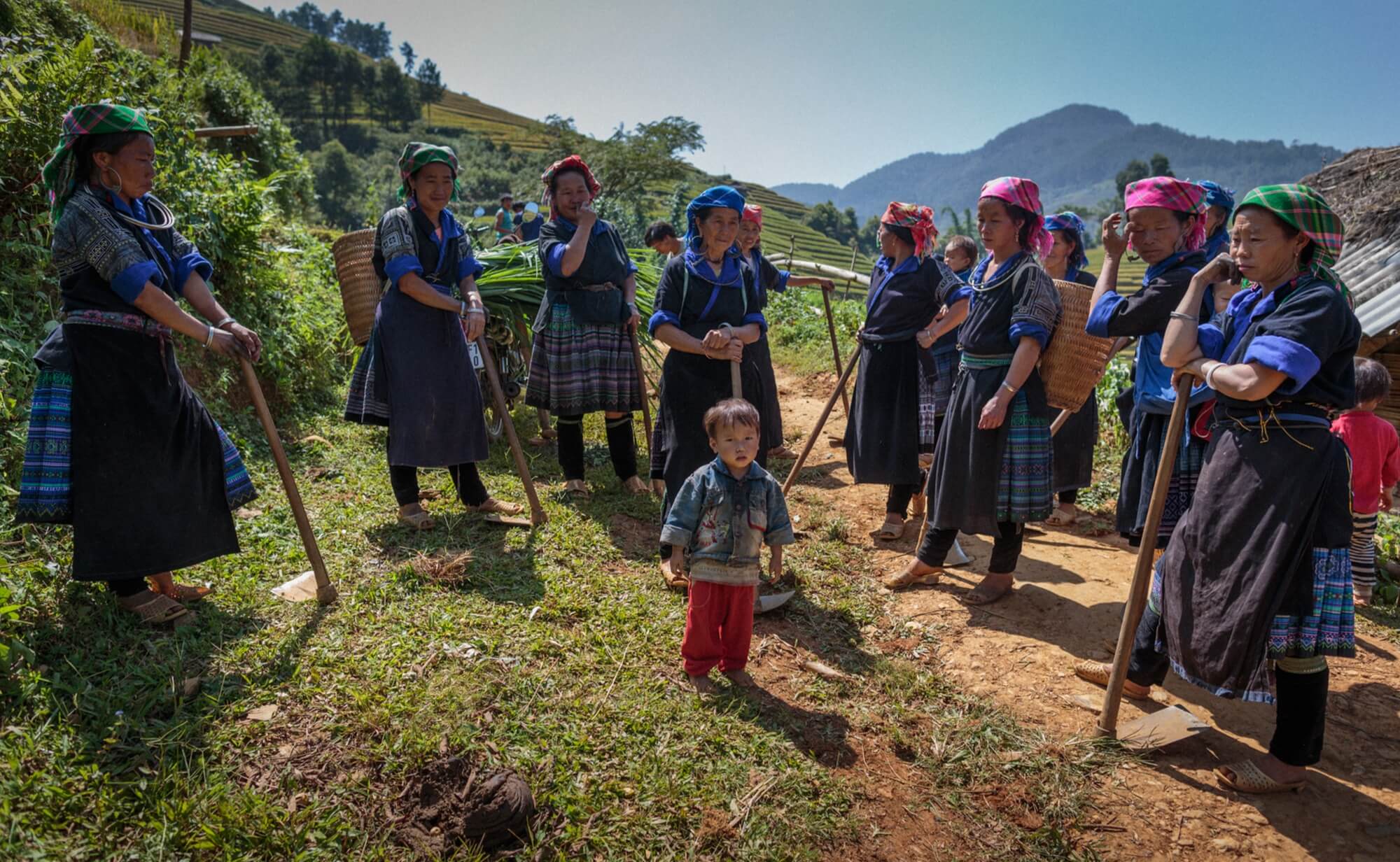 Group of Vietnam minority women in traditional outfit surrounding a child