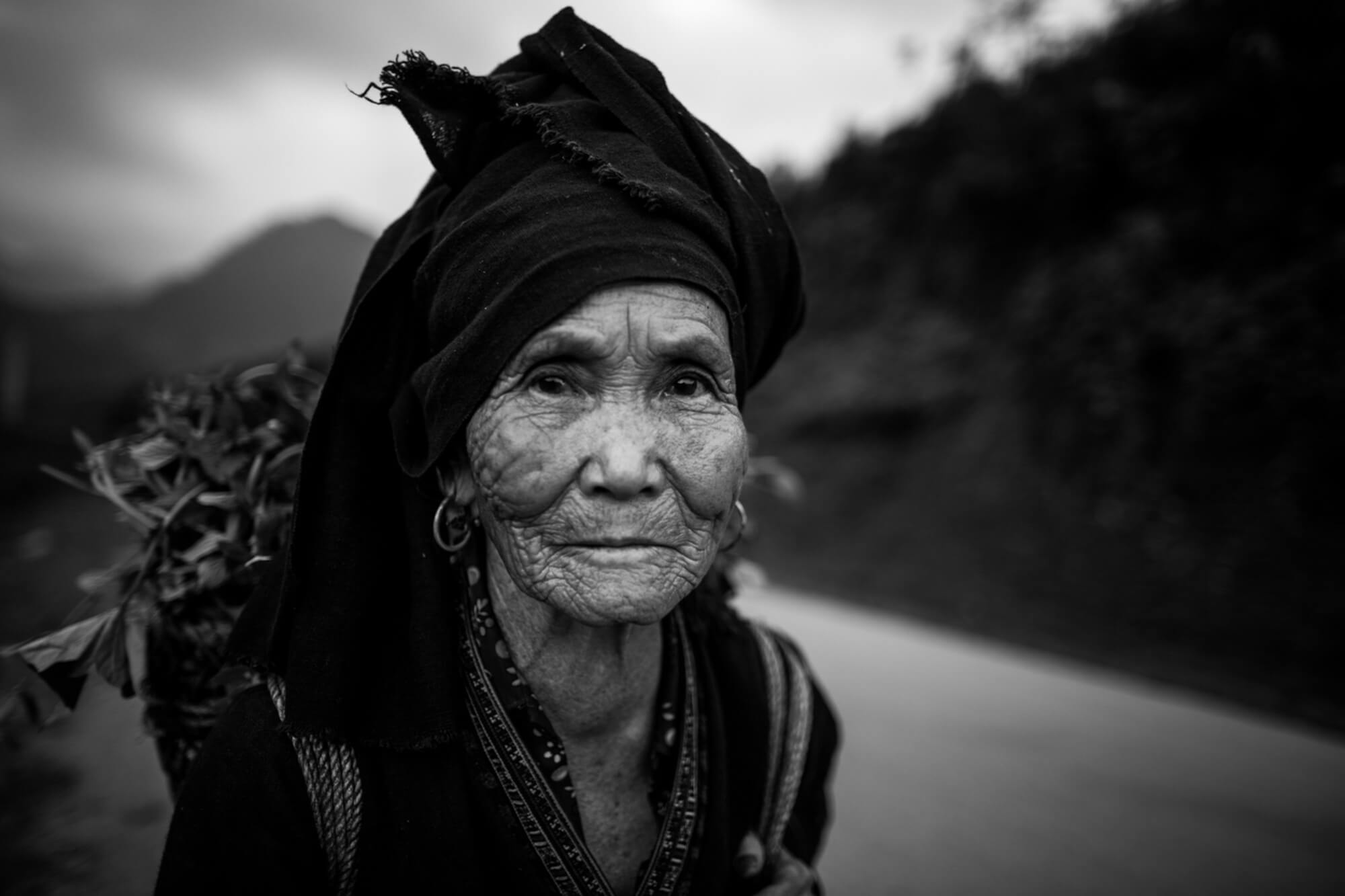 Vietnam Minority elderly woman in traditional outfit on the road