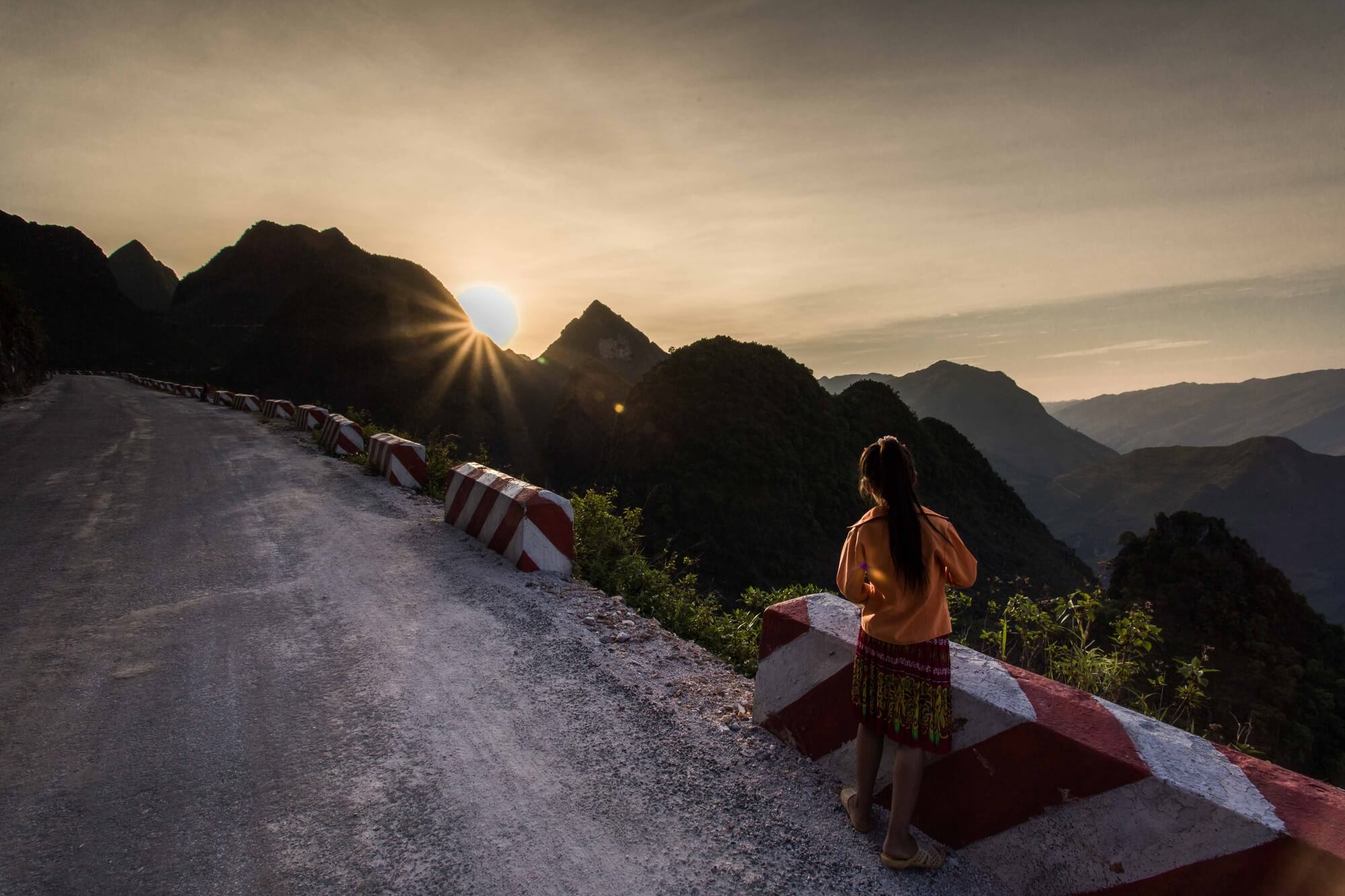 Vietnam minority girl on mountain passage watching the setting sun Vietnam minority girl on mountain passage watching the setting sun
