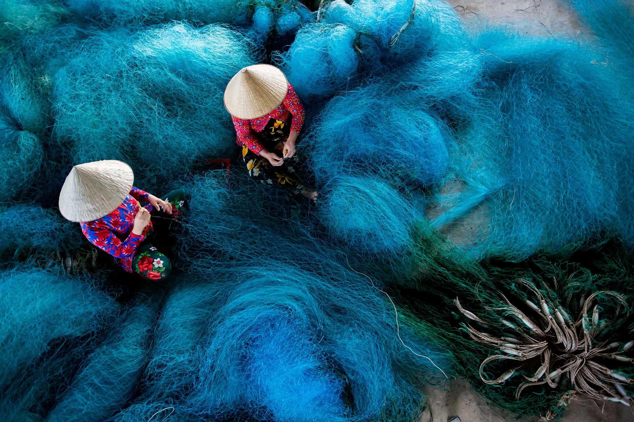 Women mending fishing nets