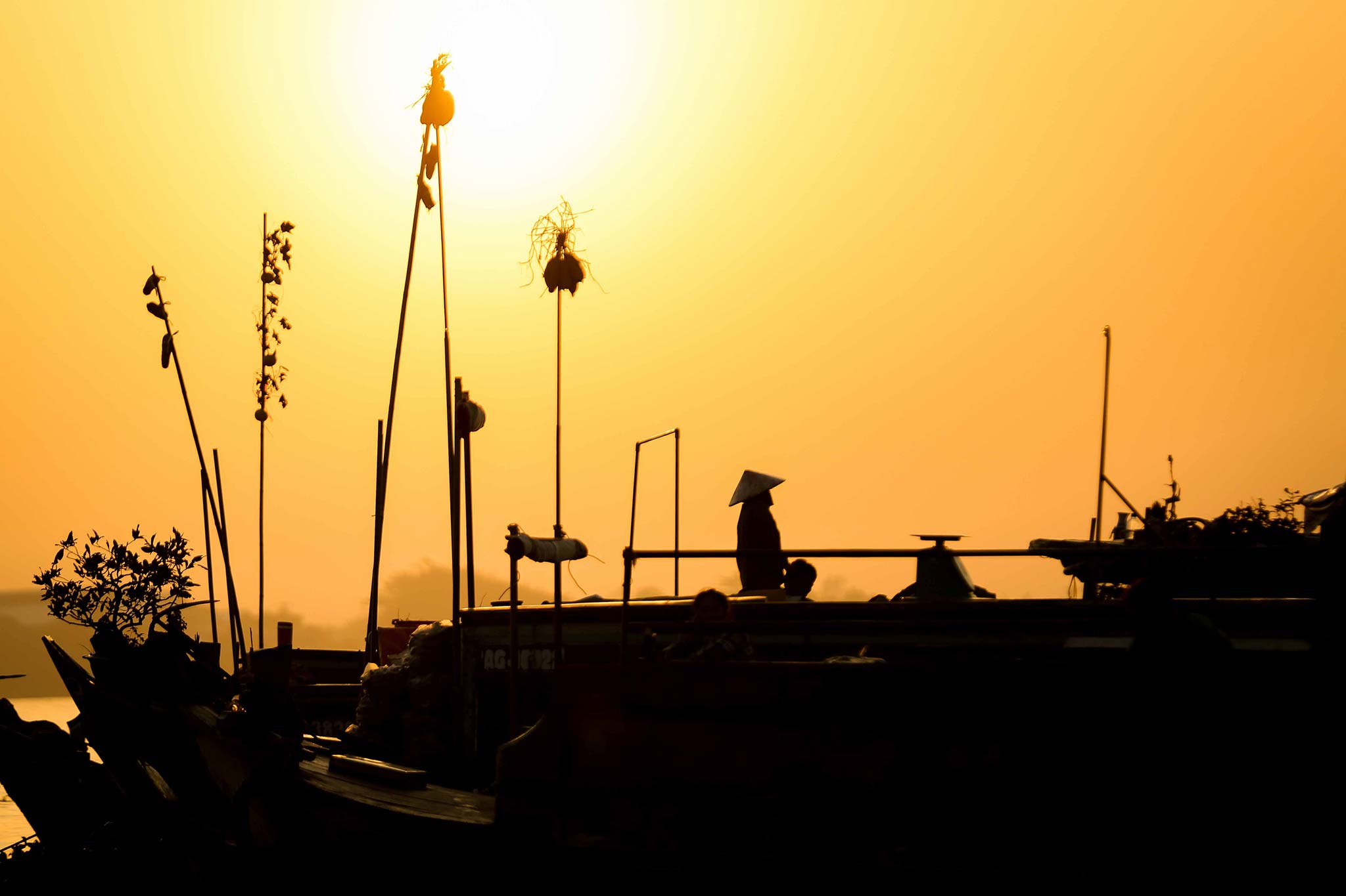 Sun rising on a wholesale boat of the Mekong Delta's floating market