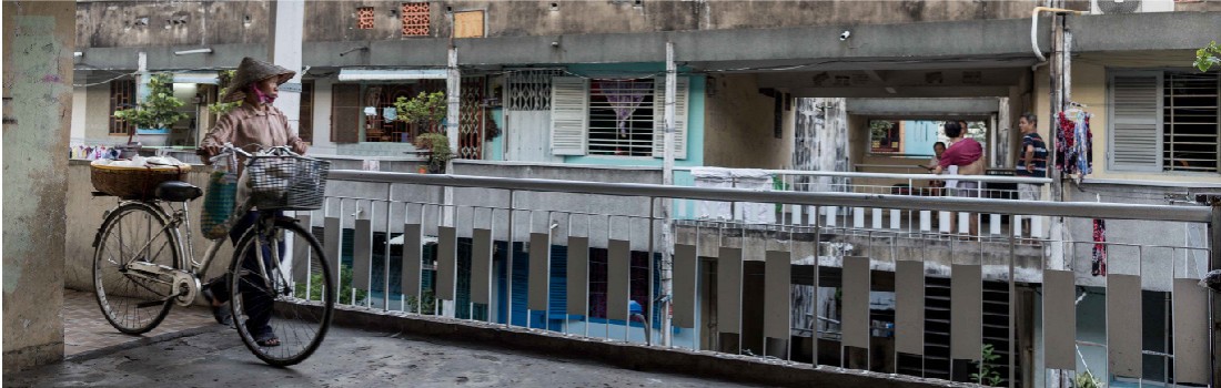 Saigon street seller with bicycle strolling through building